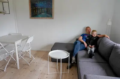 a man and a boy sitting on a couch at Feriehus Thy - I hjertet af Thy in Thisted