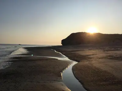 a sunset on a beach with the sun setting at Bulbjerguld BB in Frøstrup