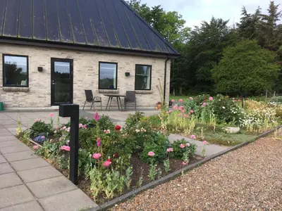 a garden with flowers in front of a building at Bulbjerguld BB in Frøstrup