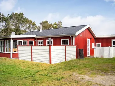 a red barn with a white fence in front of it at 6 person holiday home in Thisted-By Traum in Thisted