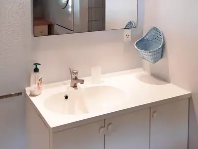 a bathroom with a white sink and a mirror at Holiday Home with Terrace & Fire Pit in Thisted