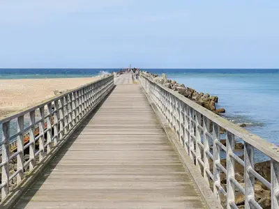 a wooden boardwalk leading to the ocean on a beach at Holiday Home with Terrace & Fire Pit in Thisted
