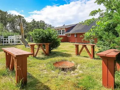 a group of picnic tables in front of a building at Holiday Home with Terrace & Fire Pit in Thisted