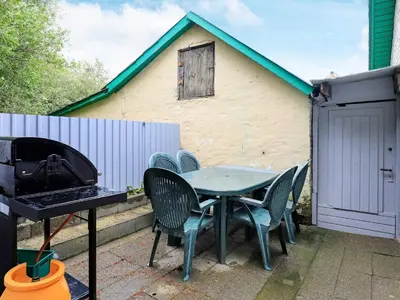 a table with chairs and a grill in front of a house at Seaside Retreat in Hvalpsund-By Traum in Farsø