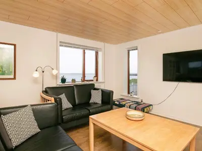 a living room with a couch and a table at Seaside Retreat in Hvalpsund-By Traum in Farsø