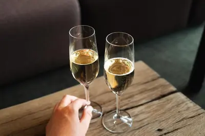 two glasses of white wine on a wooden table at Peak 12 Hotel in Viborg