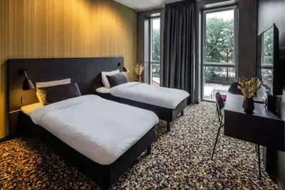 a hotel room with two beds and a window at Peak 12 Hotel in Viborg