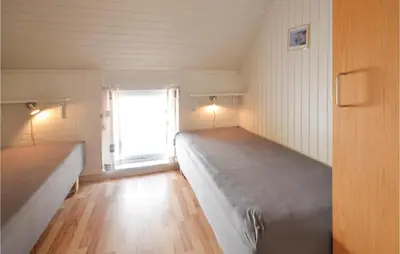 a small room with two beds and a window at 3 Bedroom Awesome Home In Thisted in Thisted