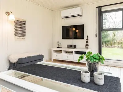 a living room with a tv and a couch at Secluded Forest Retreat-By Traum in Roslev