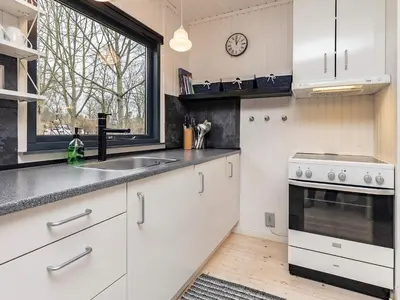 a kitchen with white cabinets and a sink and a window at Secluded Forest Retreat-By Traum in Roslev