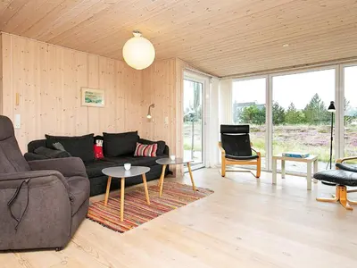 a living room with a couch and a table at Cozy Coastal Retreat in Vorupor-By Traum in Thisted