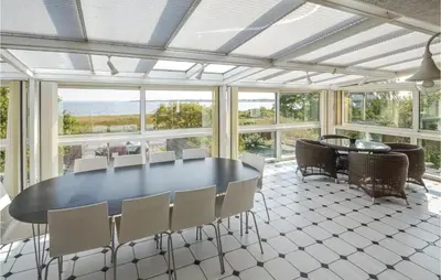 a dining room with a table and chairs and windows at Lovely Home In Fur With Kitchen in Fur