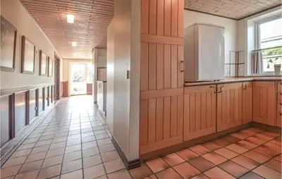 a kitchen with wood paneled walls and a refrigerator at Lovely Home In Fur With Kitchen in Fur