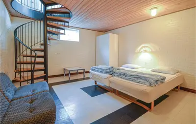 a bedroom with a bed and a spiral staircase at Lovely Home In Fur With Kitchen in Fur