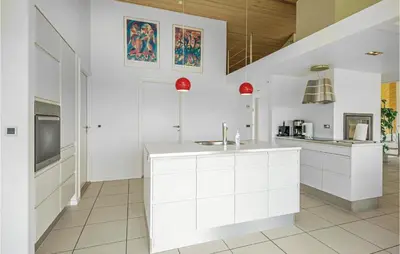 a kitchen with white cabinets and a sink at Beautiful Home In Blokhus With Kitchen in Blokhus