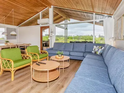 a living room with a blue couch and chairs at Type2 holiday home in Hanstholm in Hanstholm