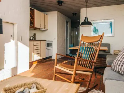 a wooden chair in a living room with a kitchen at 6 person holiday home in Brovst in Brovst