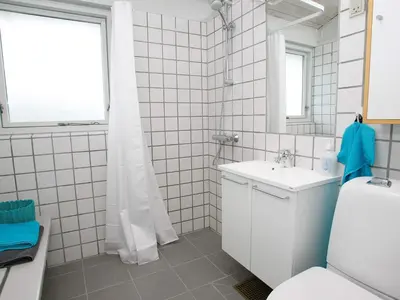 a bathroom with a sink and a toilet and a mirror at Vigsø Holiday Center in Hanstholm