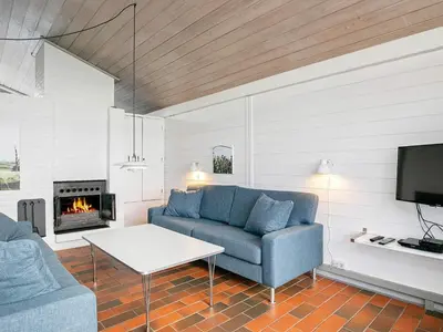 a living room with a couch and a fireplace at Vigsø Holiday Center in Hanstholm