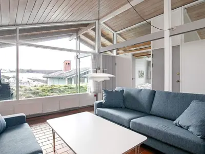 a living room with a blue couch and a table at Vigsø Holiday Center in Hanstholm