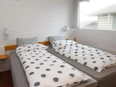 two beds sitting next to a window in a room at Vigsø Holiday Center in Hanstholm