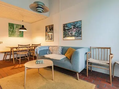 a living room with a blue couch and a table at 6 person holiday home in Brovst in Brovst