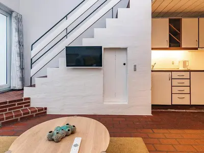 a living room with a table and a staircase at 6 person holiday home in Brovst in Brovst