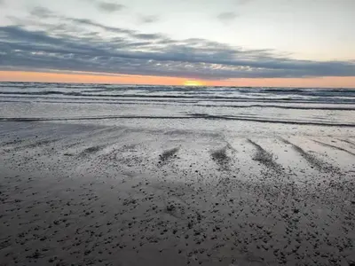 an empty beach with footprints in the sand at 6 person holiday home in Brovst in Brovst