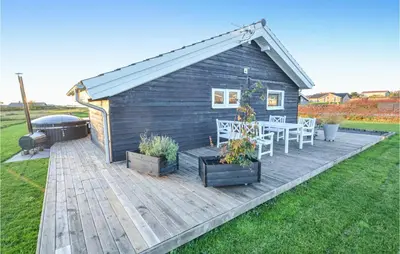 a wooden deck with a table and a grill at Lovely Home In Vinderup With Wifi in Vinderup