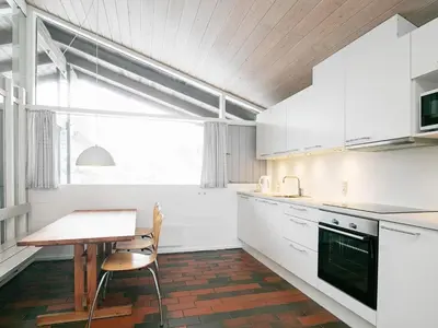 a kitchen with white cabinets and a table and a window at Room in Vigsø Holiday Park in Hanstholm