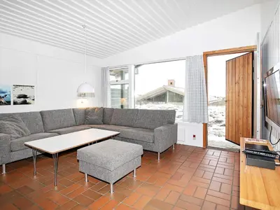a living room with a couch and a table at Modern comfort holiday home in Hanstholm