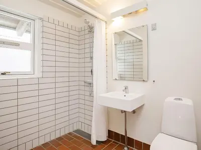 a white bathroom with a sink and a mirror at Modern comfort holiday home in Hanstholm