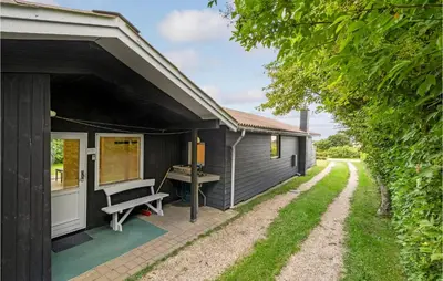 a black house with a bench on the side of it at 3 Bedroom Stunning Home In Snedsted in Snedsted