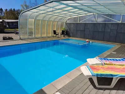 a swimming pool with a greenhouse and a swimming pool at Glyngøre Camping in Glyngøre