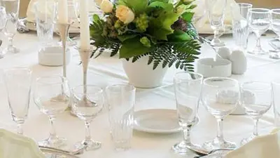 a table with wine glasses and a vase with flowers at Aars Hotel in Års