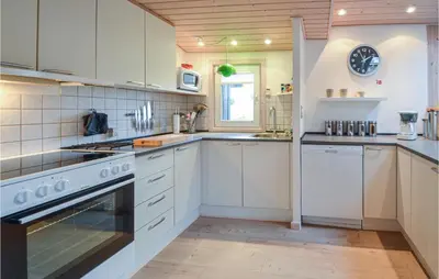 a kitchen with white cabinets and a stove top oven at Amazing Home In Thisted With Kitchen in Thisted