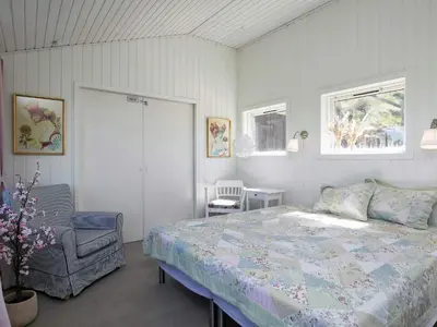 a bedroom with a bed and a chair at 6 person holiday home in Løkken in Løkken