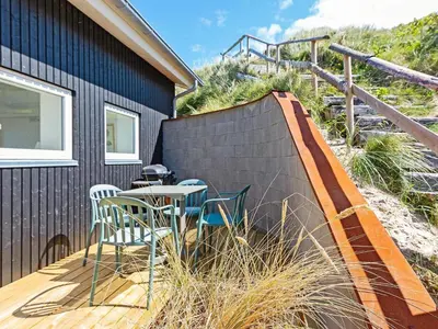 a patio with chairs and a table on a deck at 6 person holiday home in Løkken in Løkken