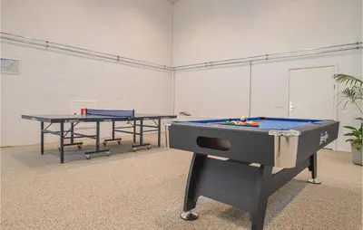 a ping pong table and two tables in a room at Feriehotel Tranum Klit in Brovst