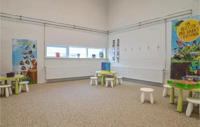 a room with tables and stools in a classroom at Feriehotel Tranum Klit in Brovst