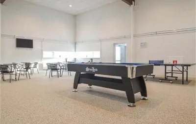 a ping pong table in a room with tables and chairs at Feriehotel Tranum Klit in Brovst