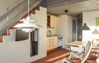 a kitchen and dining room with a table and chairs at Feriehotel Tranum Klit in Brovst
