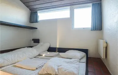 a room with two beds in it with a window at Feriehotel Tranum Klit in Brovst