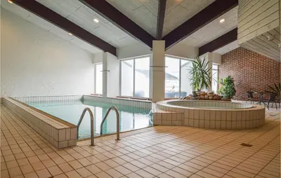 a large indoor pool with a hot tub in a building at Feriehotal Tranum Klit in Brovst
