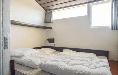 two unmade beds in a room with a window at Feriehotal Tranum Klit in Brovst