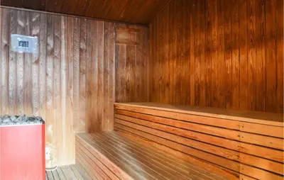 a sauna with wooden walls and a wooden floor at Feriehotal Tranum Klit in Brovst