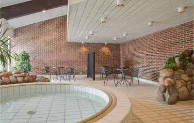 a patio with a hot tub and tables and chairs at Feriehotel Tranum Klit in Brovst