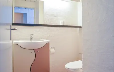 a bathroom with a sink and a toilet and a mirror at Feriehotel Tranum Klit in Brovst
