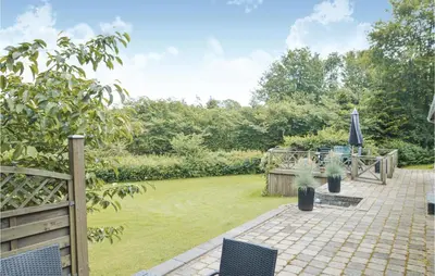a garden with a patio and a lawn at Fjordens Perle in Farsø