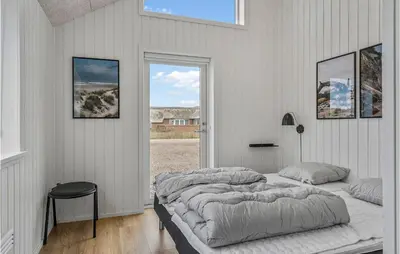 a white bedroom with two beds and a window at Nice Home In Harboøre With Sauna in Harboør